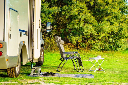 椅子和桌子在大篷车上的绿色自然。疯狂的露营。假期和旅行在汽车之家。房车露营在绿色自然