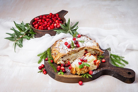 圣诞派摄影照片_美味的蔓越莓派与新鲜蔓越莓和香草的圣诞木盘子。
