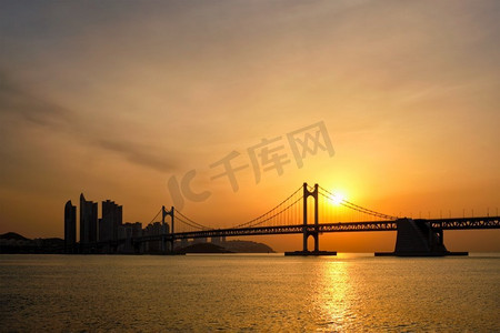 光岸大桥在日出与摩天大楼和戏剧性的天空。韩国釜山。日出的光岸大桥。韩国釜山