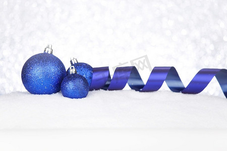 蓝色圣诞装饰在雪特写镜头。圣诞节装饰在雪地上