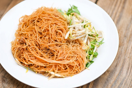 白盘炒面粉条，中式炒面配芽菜香菜木桌—泰国菜