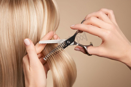 美发师用剪刀剪长长的黑发.梳子头发