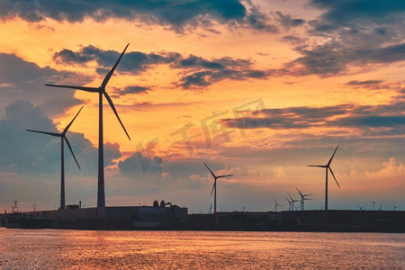 日落时分，安特卫普港的风力涡轮机为发电机供电。比利时安特卫普安特卫普港的风力涡轮机日落。