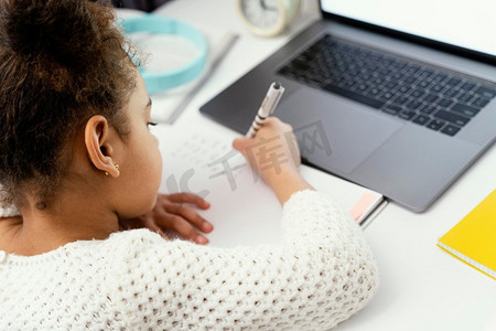 上学背景摄影照片_小女孩使用笔记本电脑在网上学校上学