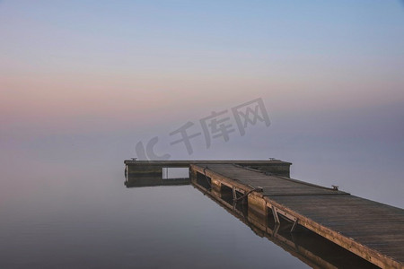 史诗般的风景图--水库湖面春日升起，黎明的光芒在低雾的水面上蔓延，增添了大气