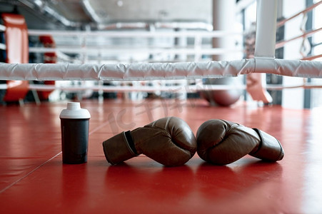 拳击手套和水瓶在拳击场地面，拳击运动器材训练和锻炼。拳击手套和水瓶环