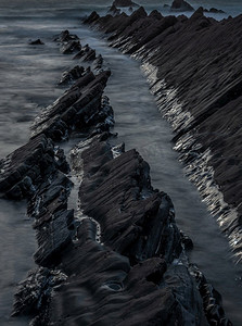 岩石的抽象风景图象在欢迎嘴海滩在日落与潮汐标记在岩石反射阳光