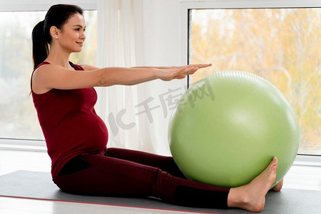 怀孕的年轻妇女锻炼健身球