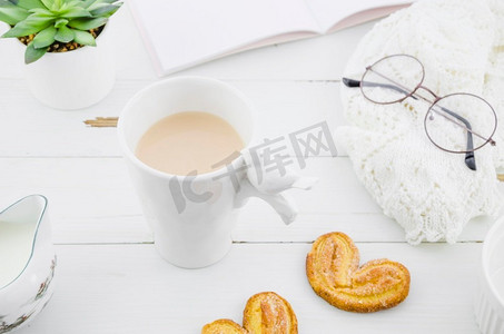 茶杯书摄影照片_palmiers粉饼饼干与瓷白茶杯木桌子