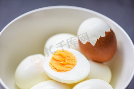蛋黄摄影照片_鸡蛋早餐，新鲜去皮鸡蛋菜单食物煮鸡蛋在碗和蛋壳，切成两半蛋黄烹饪健康饮食