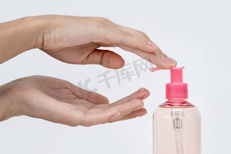 容器里的液体摄影照片_从瓶子里倒出肥皂液的人