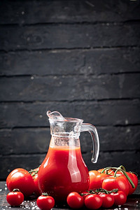桌上成熟西红柿的汁液。在黑色的木质背景上。高质量的照片。桌上成熟西红柿的汁液。