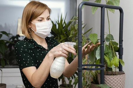 浇水卡通摄影照片_妇女与面具浇水植物