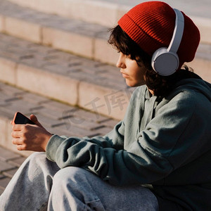 青少年户外使用智能手机听音乐耳机
