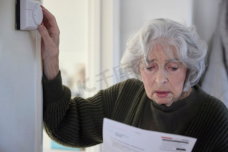 能源危机中，忧心忡忡的老妇人比尔调低了家里的中央供暖恒温器