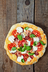 烤腊肠摄影照片_意大利腊肠、番茄和火腿披萨
