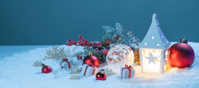 蓝色元宵灯笼摄影照片_圣诞节假期卡与礼物，球，和白色发光灯笼在雪。圣诞装饰在雪