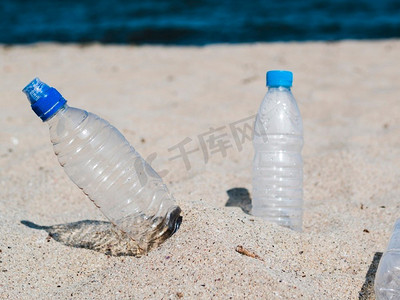 海洋塑料垃圾污染摄影照片_空塑料水瓶沙滩