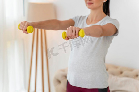黄色培训摄影照片_孕妇用黄色重量训练