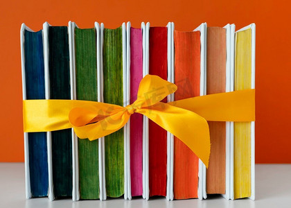 彩虹图书用黄丝带堆叠在一起