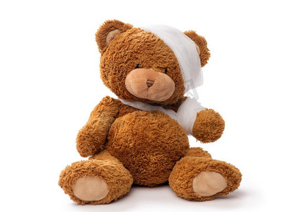 医药，保健和儿童概念—泰迪熊玩具有绷带头和爪子在白色背景。头部和爪子包扎玩具熊