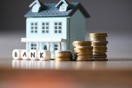 存钱或贷款银行的概念，硬币堆钱购买商业建筑或房地产和家庭投资业务。
