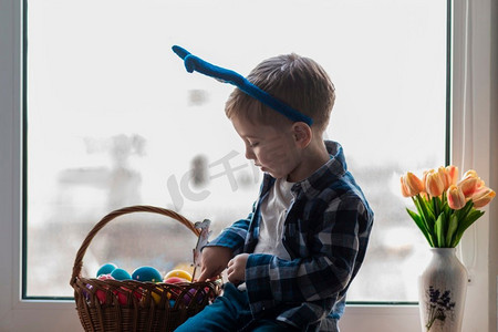 可爱的小男孩检查篮子与鸡蛋
