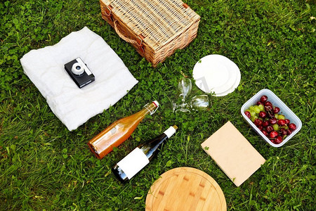 休闲和夏季概念—关闭食物，饮料和野餐篮在草地上。食物，饮料和野餐篮在草地上