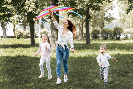 五颜六色的风筝摄影照片_孩子妈妈玩五颜六色的风筝