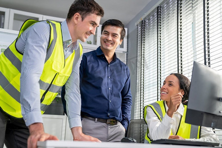 由称职的工程师和投资者组成的快乐多种族团队微笑着在餐桌上一起工作