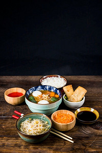 泰国鱼丸汤春卷豆芽酱筷子木桌子反对黑色背景