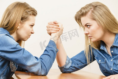 两个争强好胜的女人在摔跤，互相竞争。两名女子摔跤打架