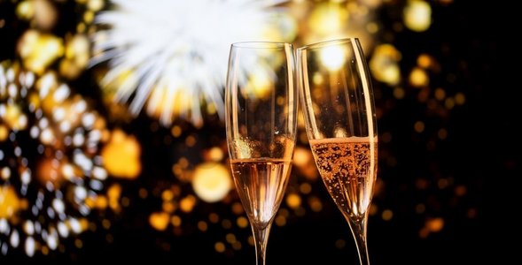 两个香槟酒杯和节日灯光祝新年快乐