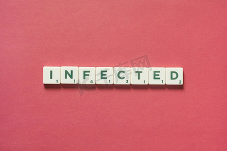 状字摄影照片_感染的字形成的涂鸦瓷砖在红色背景。感染预防和身体健康意识。感染的是由涂鸦砖形成的。