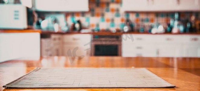 棕色桌子摄影照片_模糊的厨房内部，餐巾放在桌子上