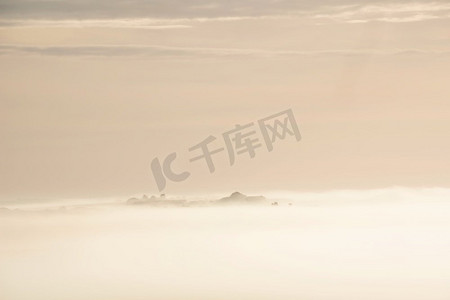 云层翻滚摄影照片_春天的日出时，雾海在英国南部唐斯乡村翻滚的美丽风景