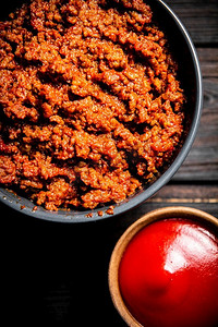 波隆沙司配番茄酱在碗里。在一个木制的背景。高质量的照片。波隆沙司配番茄酱在碗里。 
