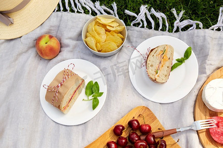 休闲与饮食理念--将食物或零食放在夏日花园的野餐毯上。在花园野餐时近距离观看食物或零食
