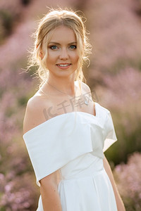 田野国风摄影照片_穿着白色连衣裙的新娘走在薰衣草田野上