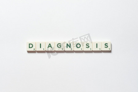 身体意识摄影照片_诊断词形成的拼字块在白色背景。疾病预防和身体健康意识。诊断由拼字障碍形成。