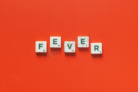 热词形成的拼字砖橙色背景。病毒感染与医疗理念发烧由拼字瓷砖形成。