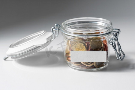 慈善、捐赠、节约的理念--玻璃瓶里的硬币特写。玻璃瓶中的硬币，用于捐赠或储蓄