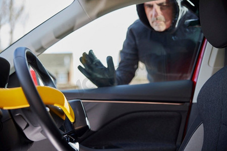 男小偷透过车窗看手动方向盘锁在车里