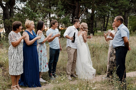 亲朋好友摄影照片_用新婚夫妇的微笑和拥抱向亲朋好友和宾客的婚礼祝贺