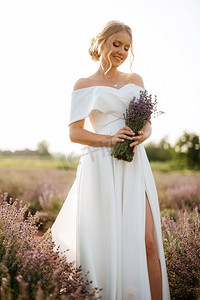 新娘穿着白裙子走在熏衣草的田野上