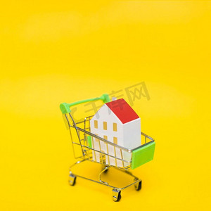 关闭房子模型微型购物车反对黄色背景