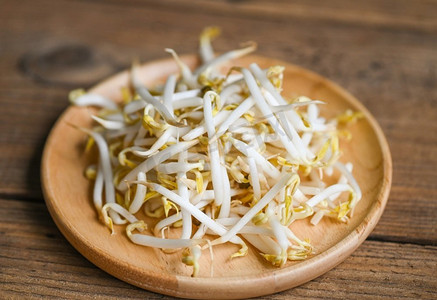 在厨房的木板桌背景上放豆芽，生白有机豆芽或绿豆芽作为素食
