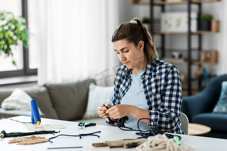 DIY，手工和爱好概念-女人在家里的桌子上制作或打结马克龙。女人在家里的桌子上制作或打结抹布
