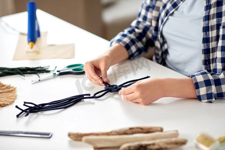 DIY，手工和爱好概念—妇女近摄做macrame工艺品和打结绳索在桌子上在家里做马缎和打结绳的妇女