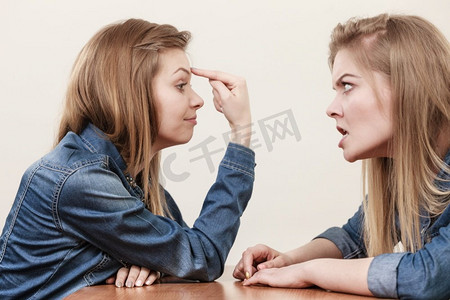 女性生气摄影照片_两个女人吵了起来，假装对对方发火。女性发泄、愚昧掩盖的观念..两个女人吵了起来